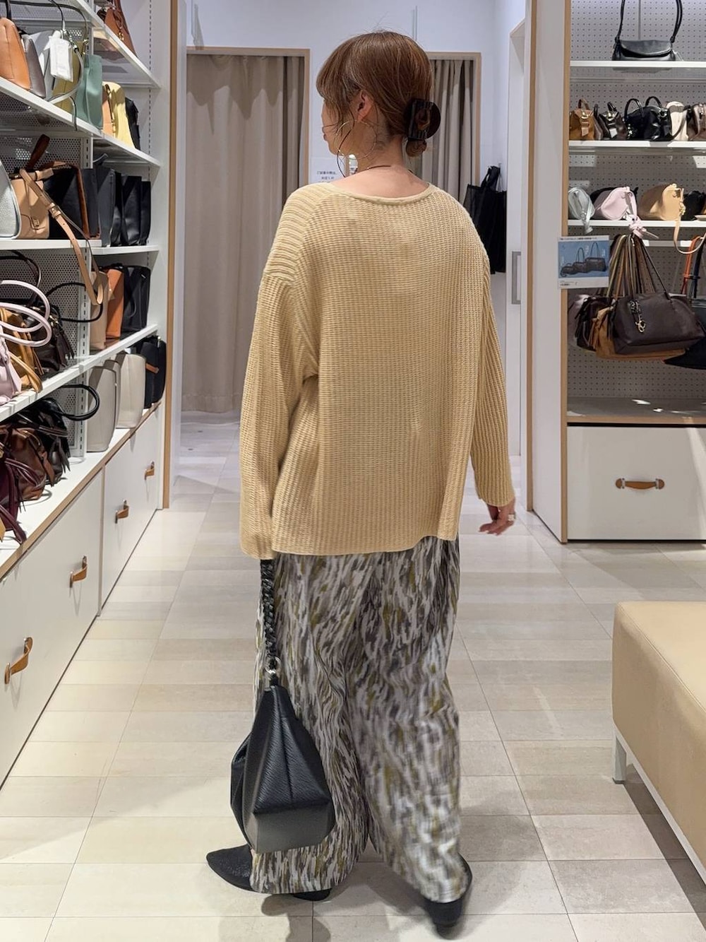 ブラック系のパンプス、ベージュ系のその他パンツ、イエロー系のニット/セーターを着用したレディースの春コーディネートの3枚目の写真