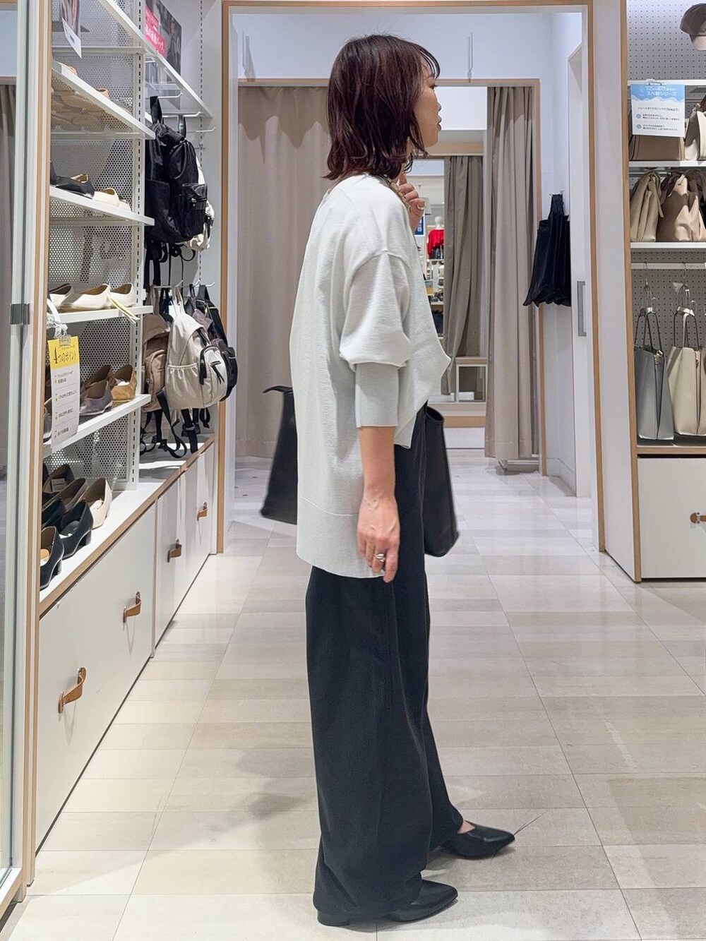 ベージュ系のスニーカー、グリーン系のスウェット、グレー系のトートバッグを着用したレディースの秋コーディネートの5枚目の写真