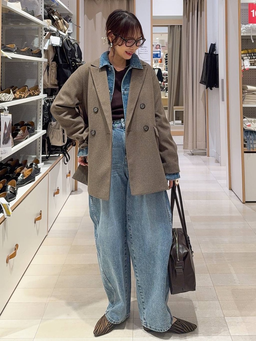 その他のパンプス、ブラウン系のボストンバッグ、ブルー系のデニムパンツを着用したレディースの冬コーディネートの2枚目の写真