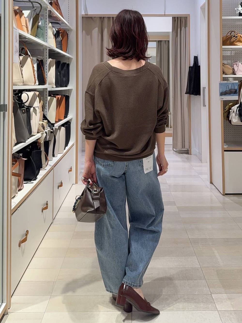 ブルー系のデニムパンツ、ブラウン系のキャミソール、ブラウン系のローファーを着用したレディースの春コーディネートの5枚目の写真