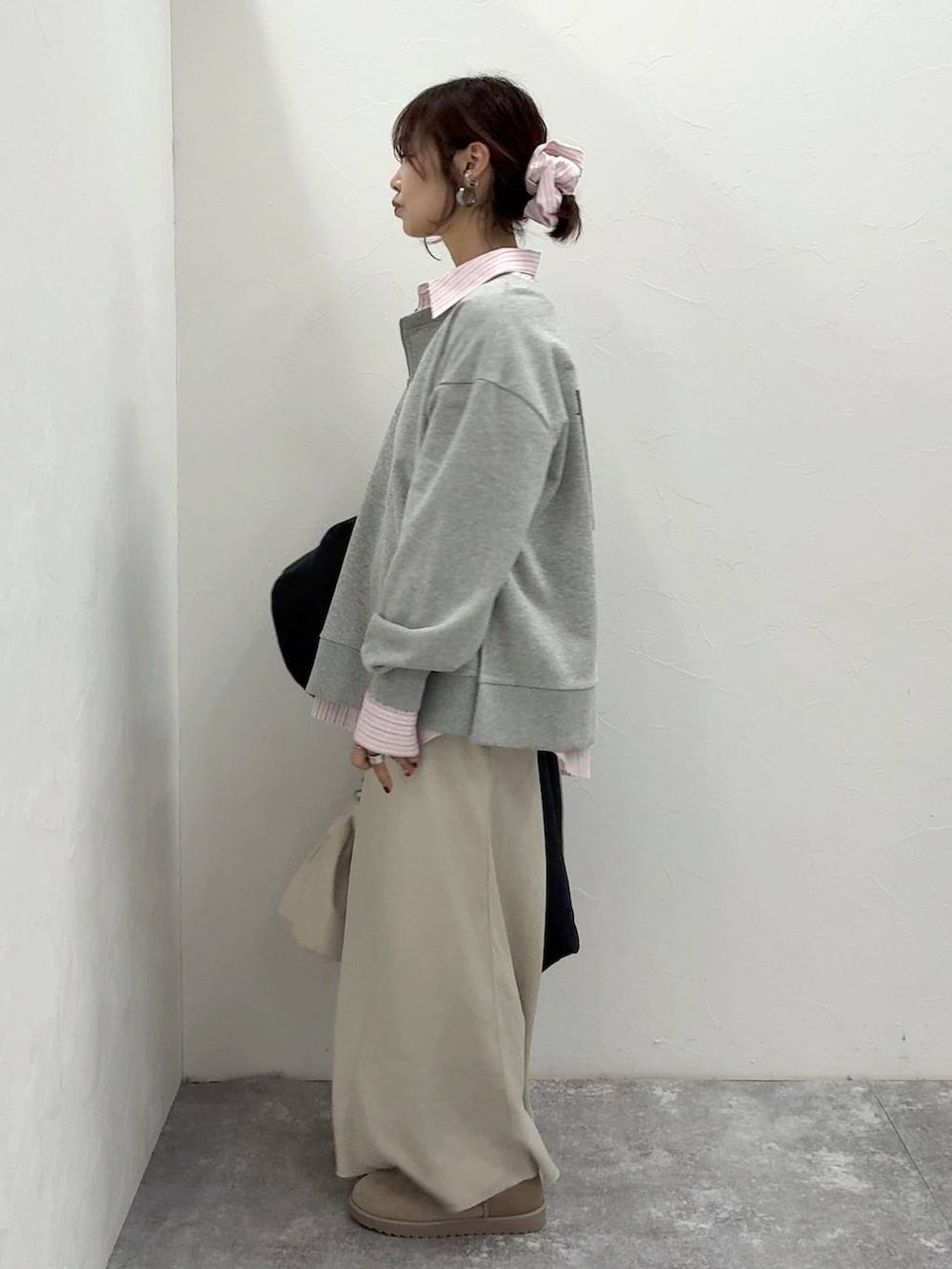 ホワイト系のショルダーバッグ、ブラック系のダウンジャケット/コート、ホワイト系のスカートを着用したレディースの冬コーディネートの6枚目の写真