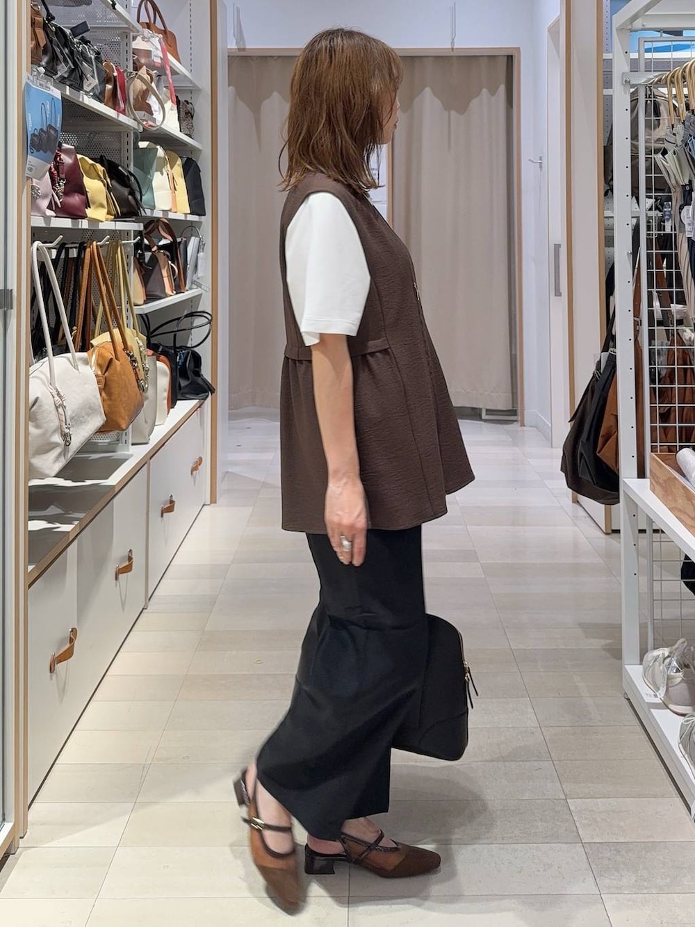 ブラック系のボストンバッグ、ブラック系のその他パンツ、ブラウン系のベストを着用したレディースの夏コーディネートの4枚目の写真