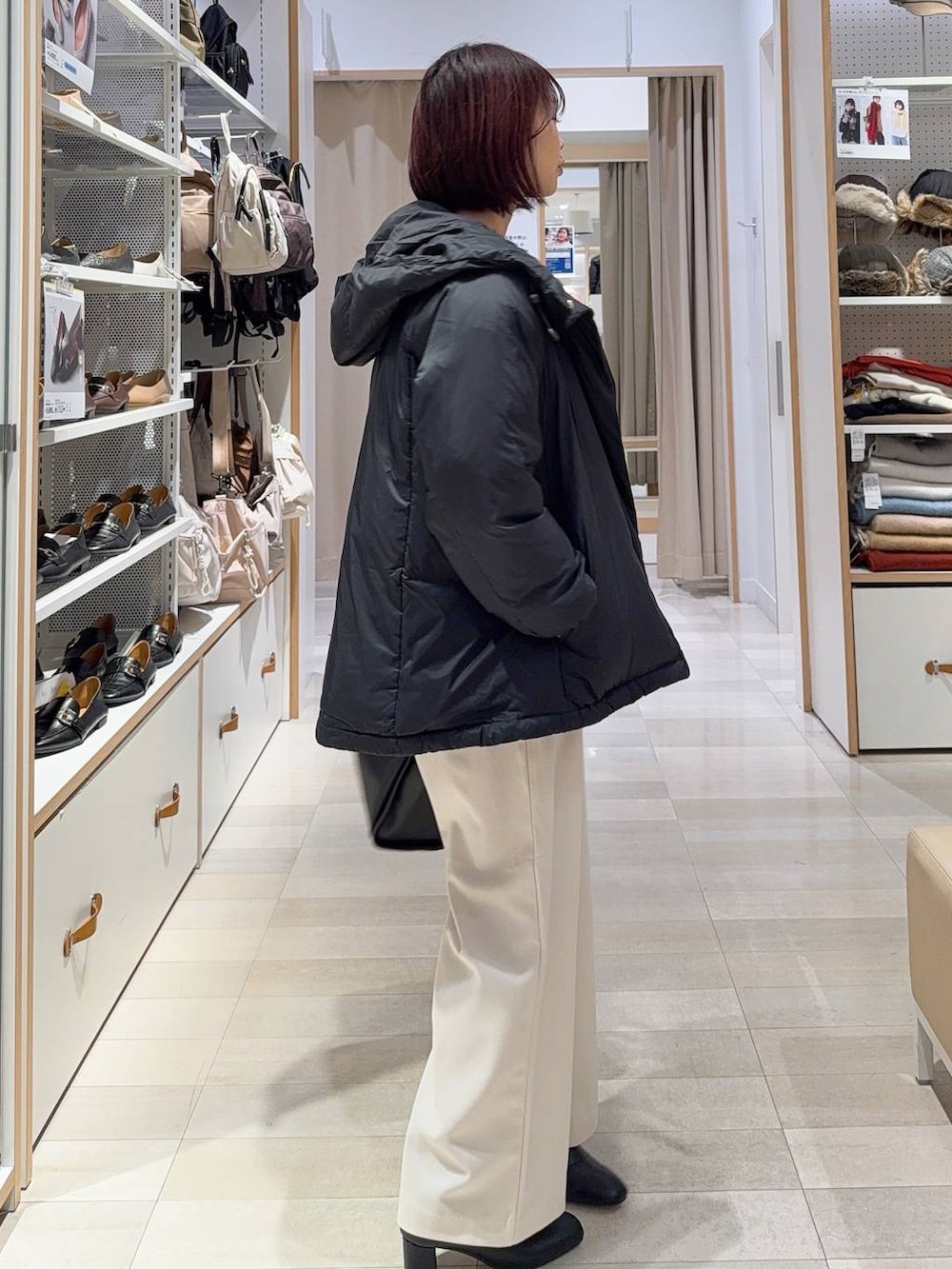 ブラック系のダウンジャケット/コート、ブラック系のトートバッグ、グレー系のその他パンツを着用したレディースの冬コーディネートの3枚目の写真