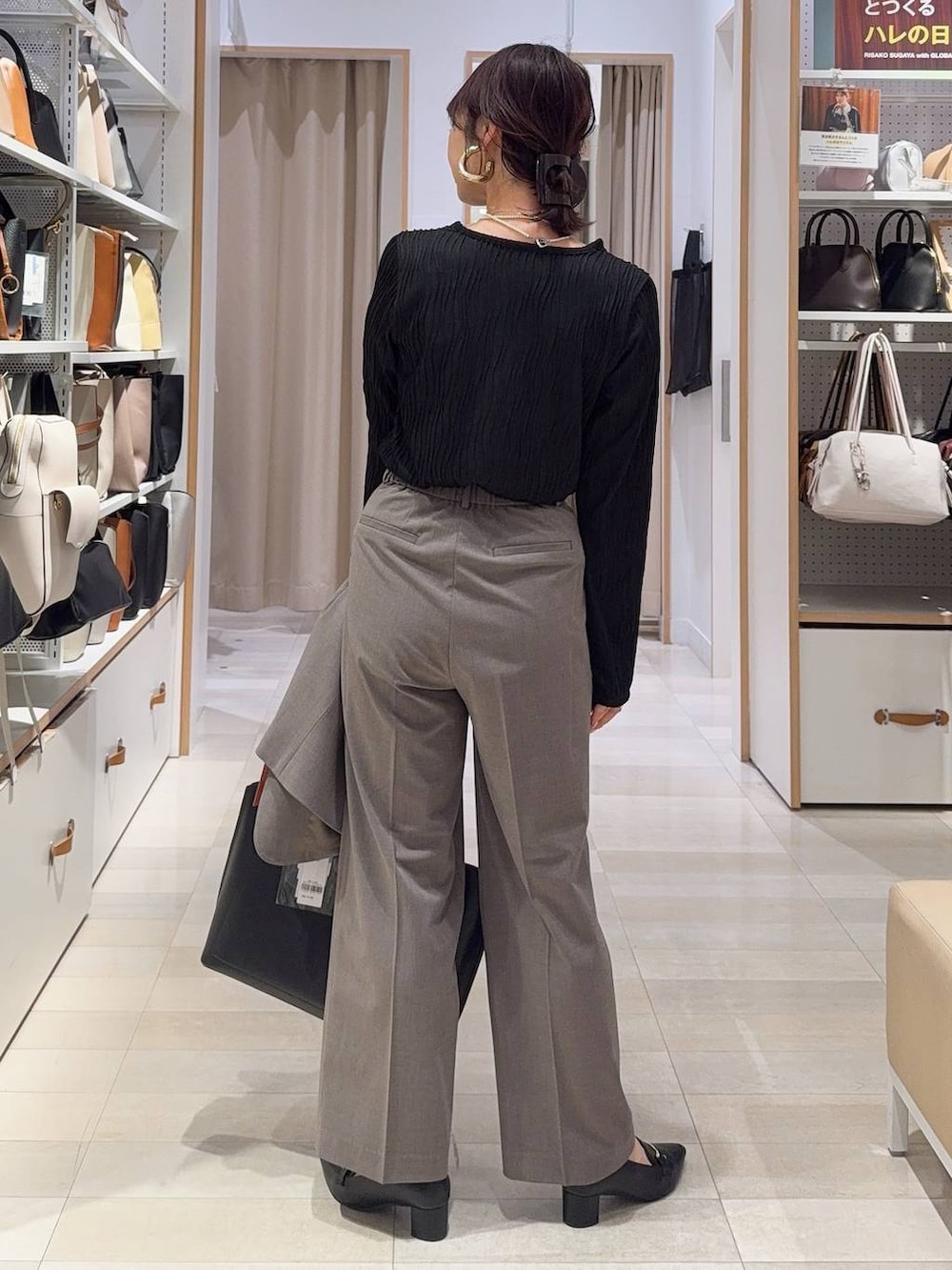 ブラウン系のスラックス、ブラック系のTシャツ/カットソー、ブラック系のトートバッグを着用したレディースの冬コーディネートの9枚目の写真