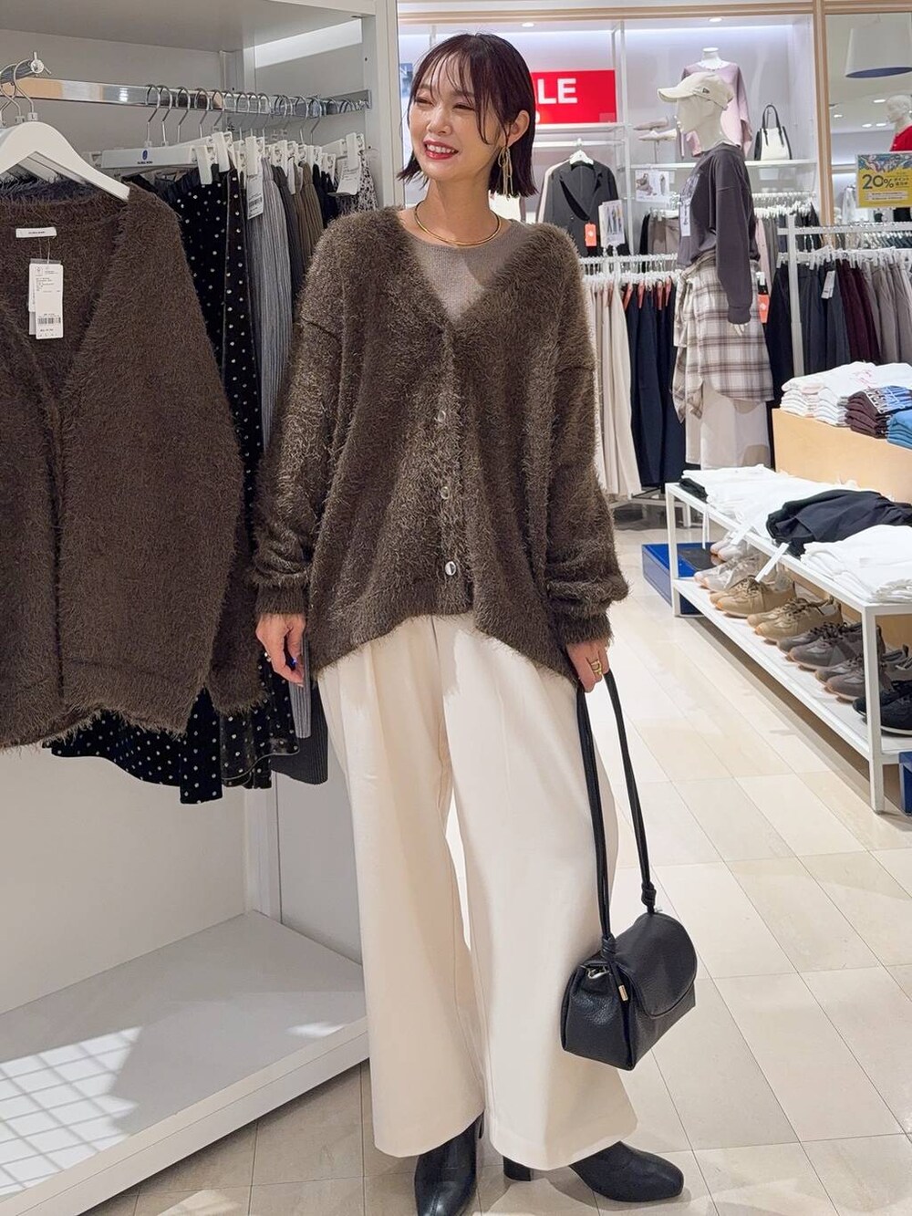 ブラウン系のボストンバッグ、ブラック系のブーツ、ブラウン系のカーディガン/ボレロを着用したレディースの冬コーディネートの3枚目の写真