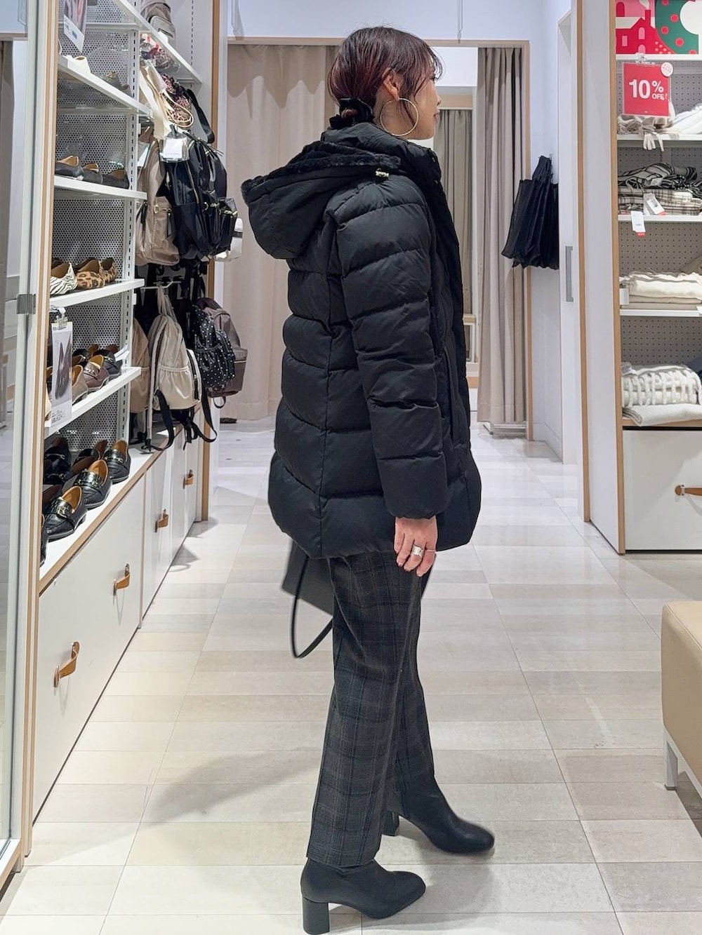 ブラック系のダウンジャケット/コート、ブラック系のその他パンツ、グレー系のニット/セーターを着用したレディースの冬コーディネートの4枚目の写真