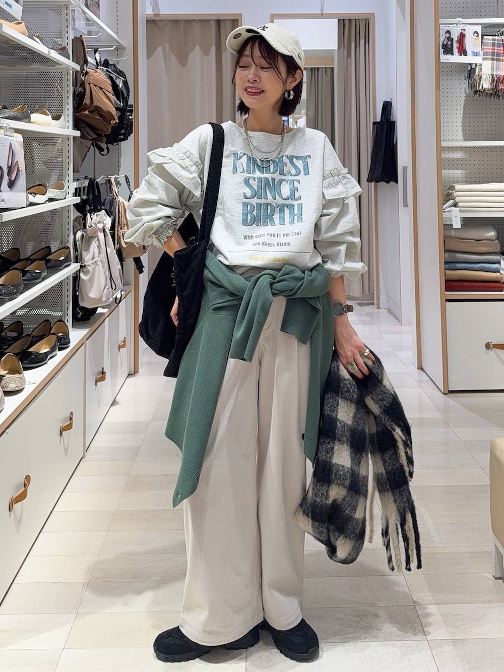 グリーン系のカーディガン/ボレロ、グレー系のその他パンツ、グレー系のトートバッグを着用したレディースの秋コーディネートの3枚目の写真