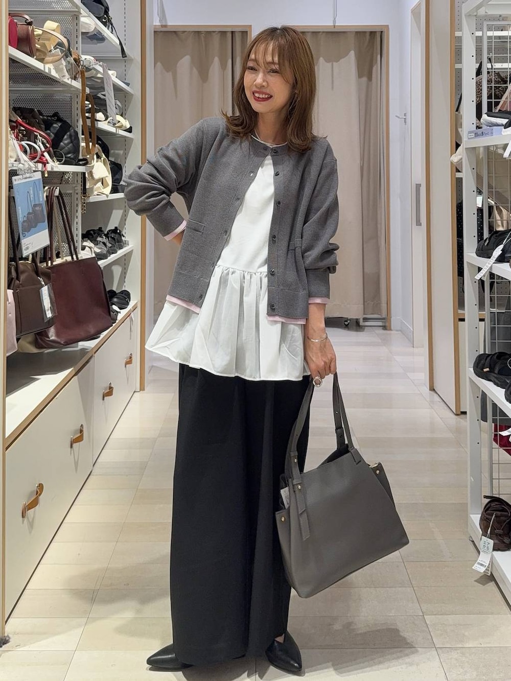 グレー系のトートバッグ、ホワイト系のTシャツ/カットソー、ブラック系のその他パンツを着用したレディースの秋コーディネートの2枚目の写真