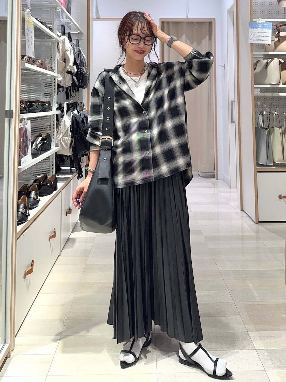 グリーン系のボストンバッグ、ブラック系のキャミソール、ブラック系のシャツ/ブラウスを着用したレディースの秋コーディネートの3枚目の写真