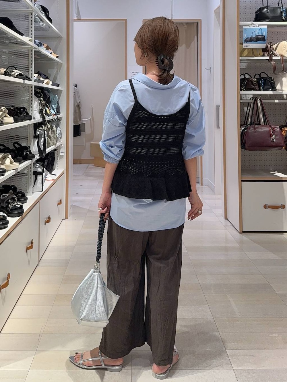 ブルー系のシャツ/ブラウス、ブラウン系のその他パンツ、ブラック系のベストを着用したレディースの夏コーディネートの9枚目の写真