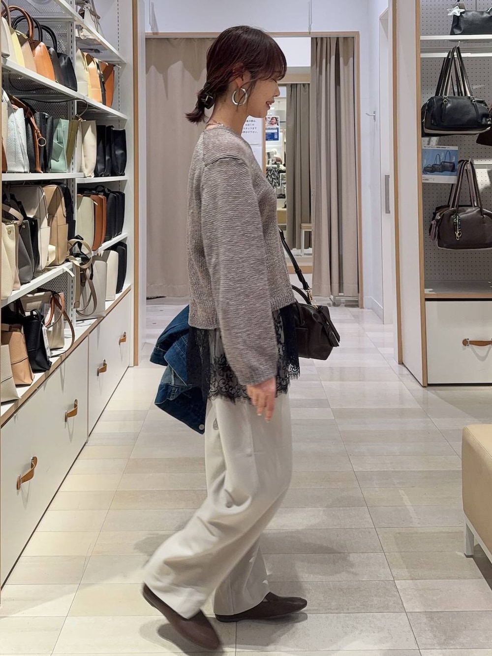 ブルー系のデニムジャケット、ブラウン系のボストンバッグ、ベージュ系のその他パンツを着用したレディースの春コーディネートの5枚目の写真