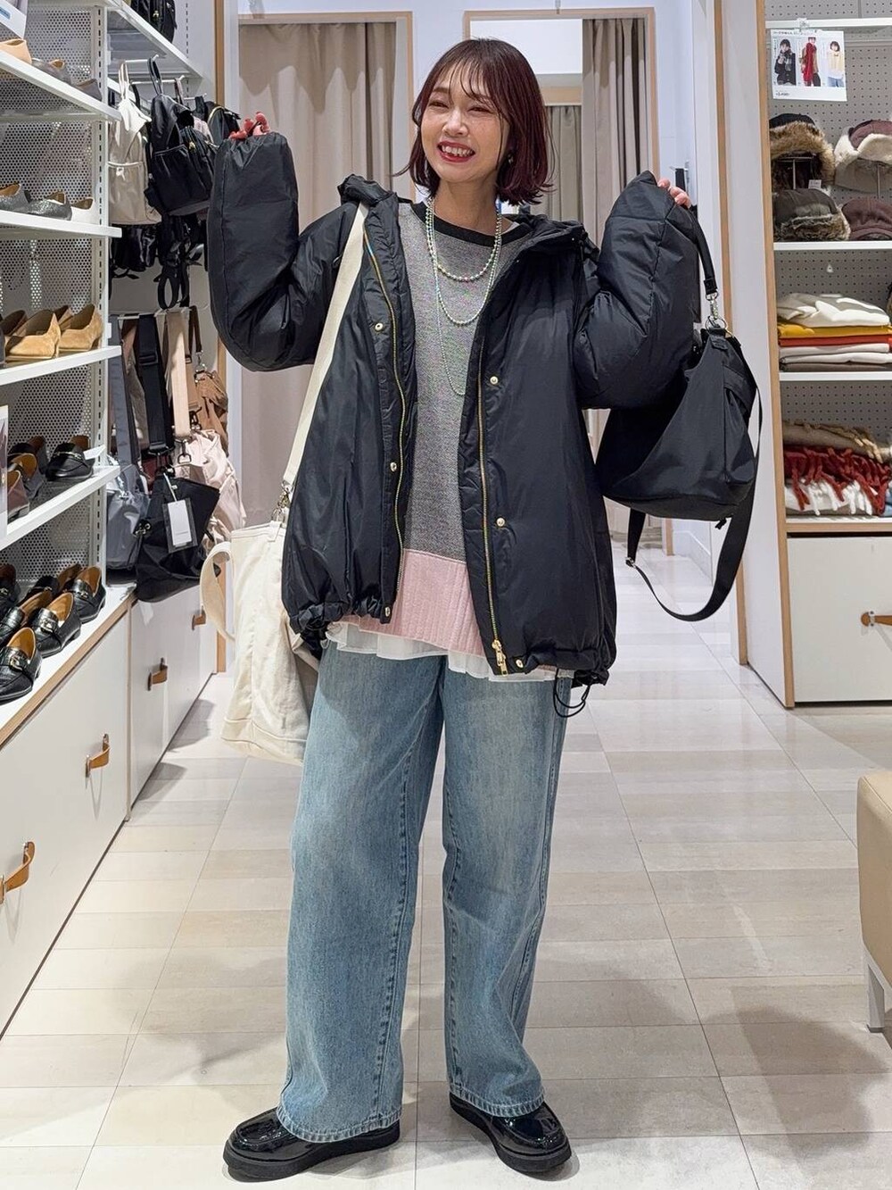 ブラック系のローファー、ブラック系のショルダーバッグ、ブラック系のダウンジャケット/コートを着用したレディースの冬コーディネートの2枚目の写真