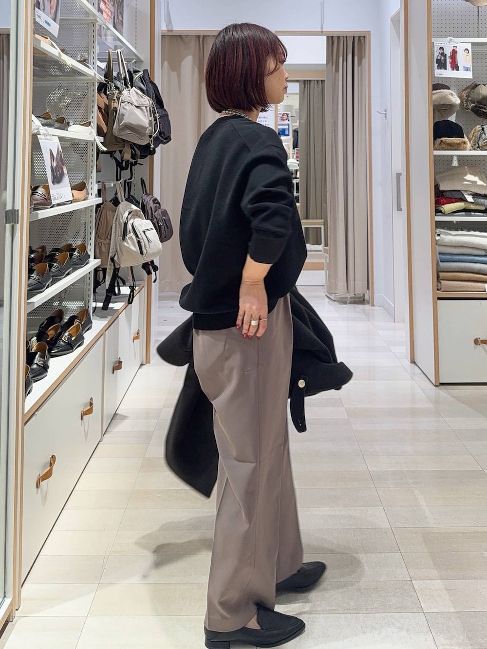 グリーン系のショルダーバッグ、ブラック系のチェスターコート、ブラック系のスウェットを着用したレディースの秋コーディネートの6枚目の写真