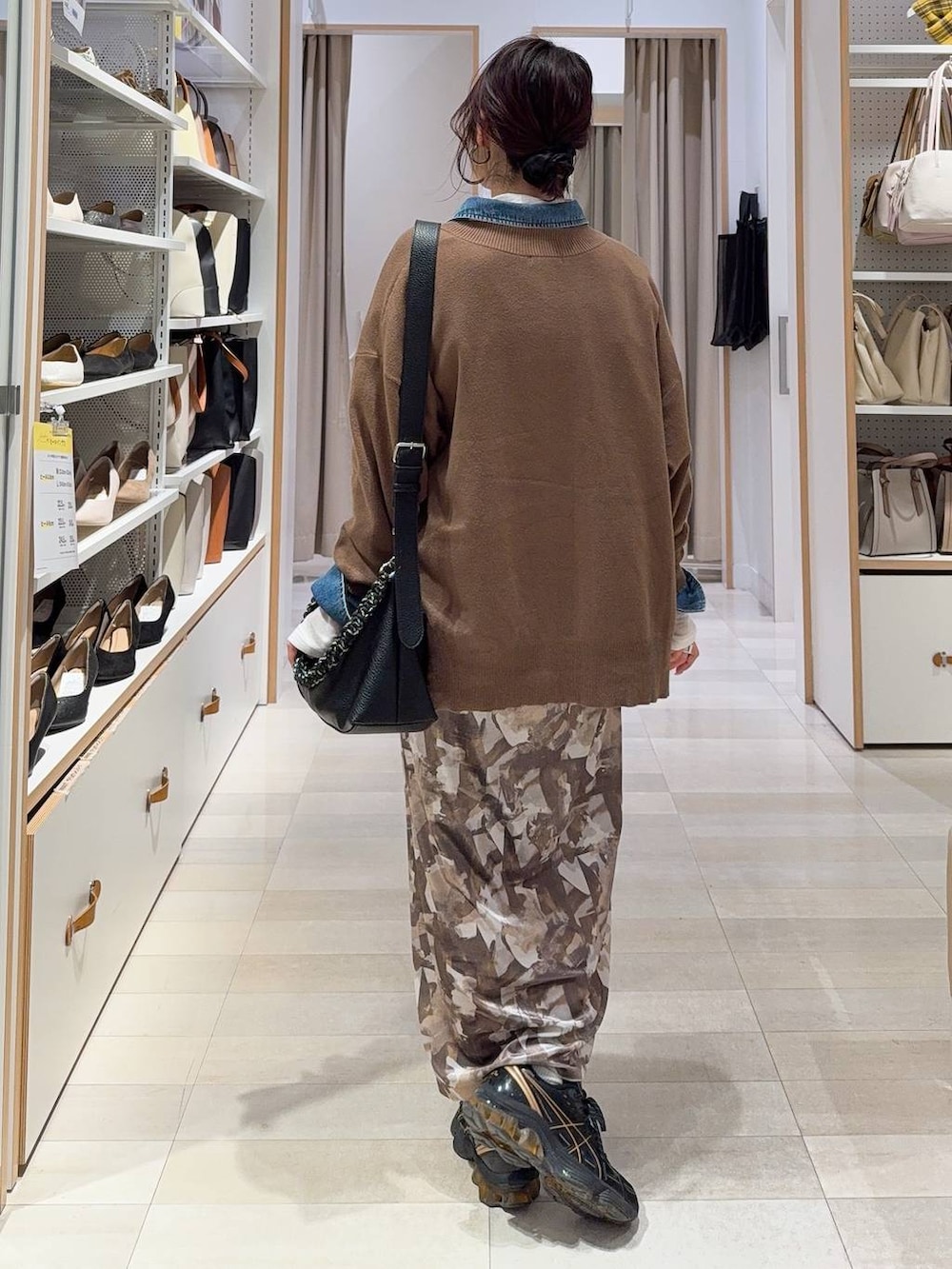 ブラウン系のニット/セーター、ホワイト系のTシャツ/カットソー、ブルー系のシャツ/ブラウスを着用したレディースの冬コーディネートの9枚目の写真