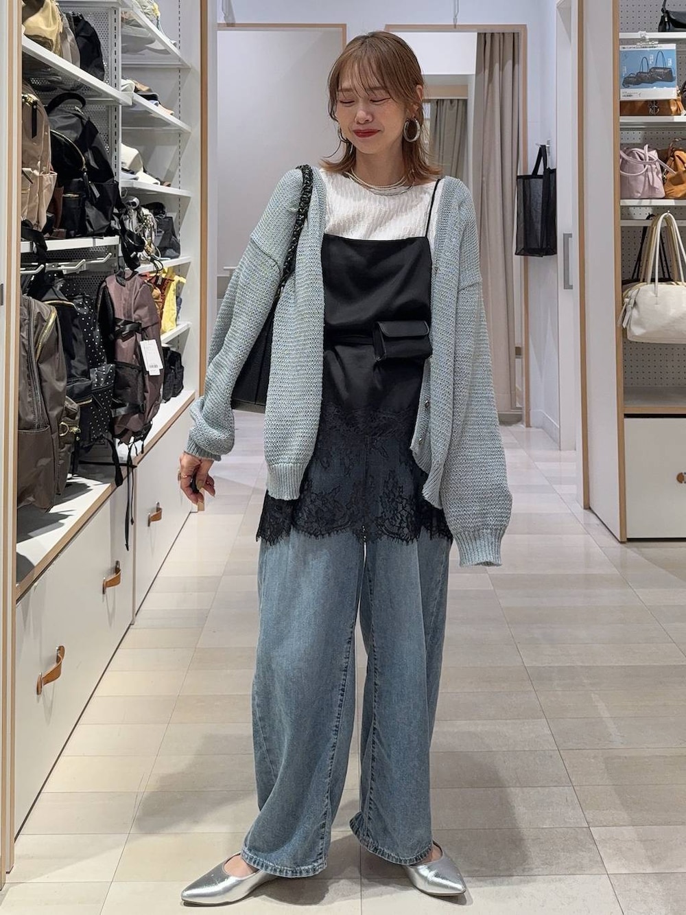 ブルー系のデニムパンツ、ブラック系のキャミソール、ブルー系のカーディガン/ボレロを着用したレディースの春コーディネートの3枚目の写真
