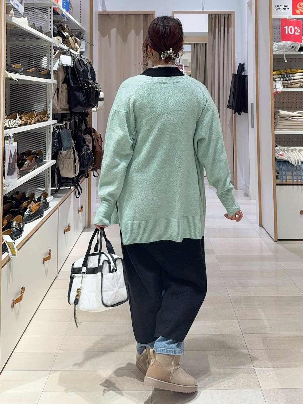 グリーン系のカーディガン/ボレロ、ホワイト系のボストンバッグ、ブラック系のワンピースを着用したレディースの冬コーディネートの5枚目の写真