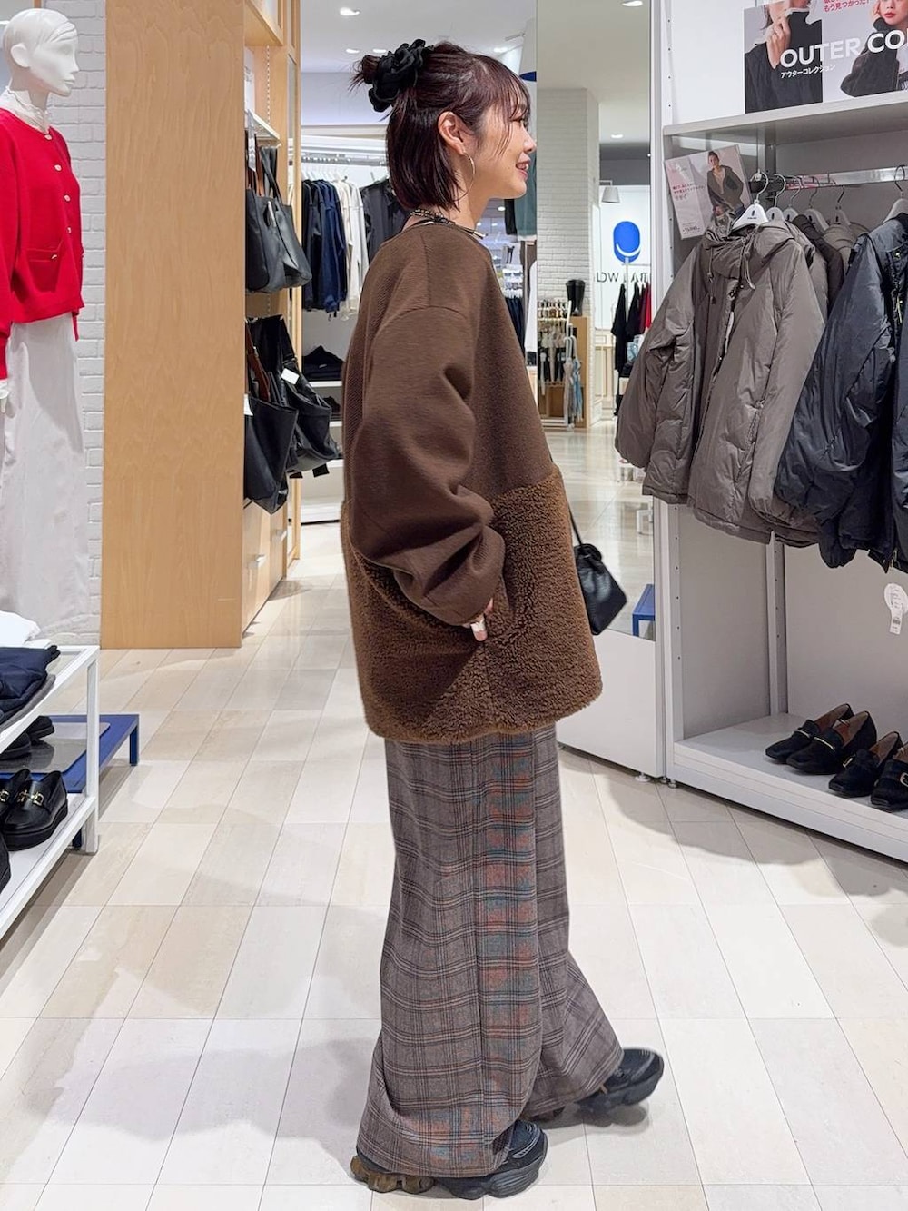 ブラック系のチェスターコート、ブラック系のショルダーバッグ、ホワイト系のTシャツ/カットソーを着用したレディースの秋コーディネートの6枚目の写真