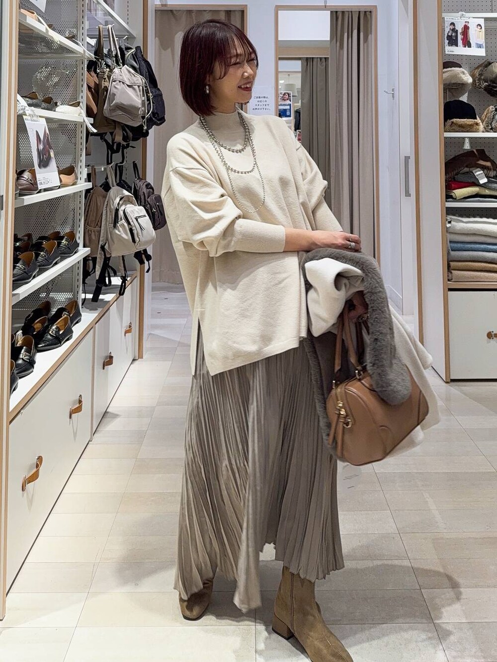 ブラック系のボストンバッグ、ブラック系のダウンジャケット/コート、ブルー系のデニムパンツを着用したレディースの秋コーディネートの3枚目の写真