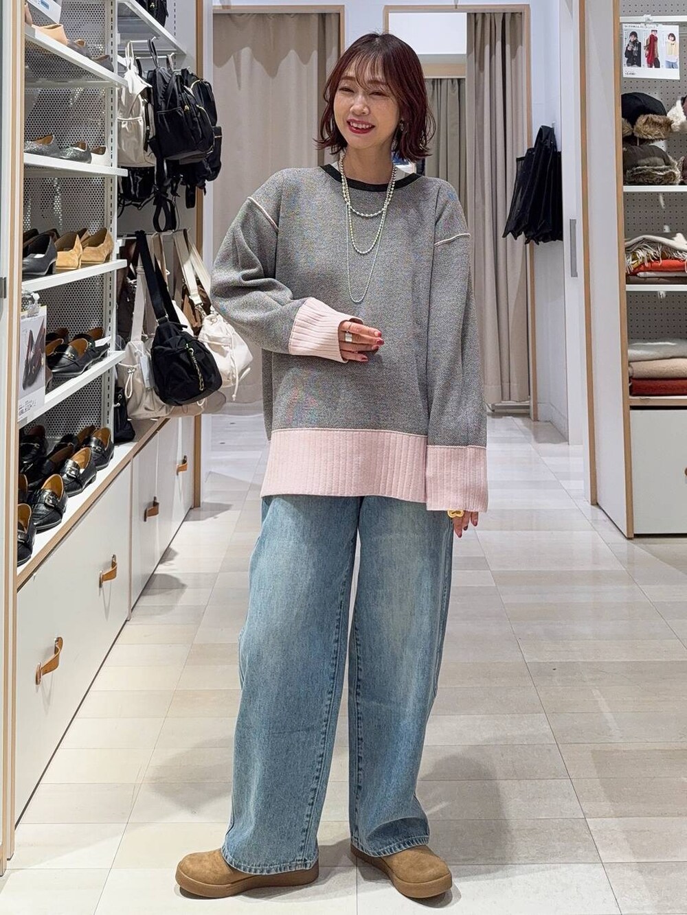 ブラック系のショルダーバッグ、ホワイト系のTシャツ/カットソー、ブラック系のブーツを着用したレディースの冬コーディネートの5枚目の写真