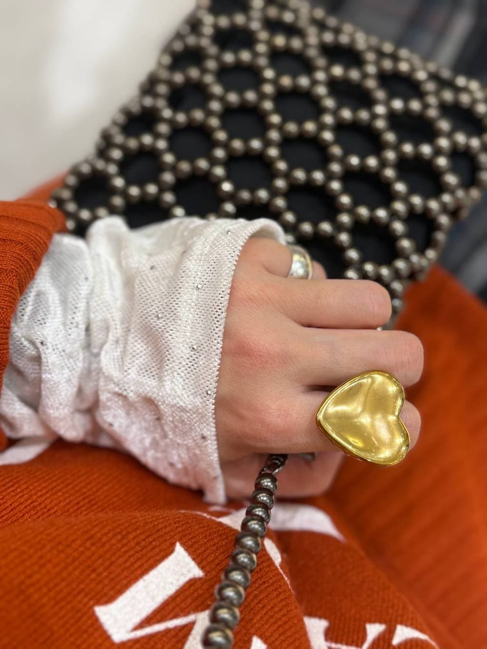 ブラック系のショルダーバッグ、ブルー系のチェスターコート、イエロー系のブーツを着用したレディースの冬コーディネートの3枚目の写真