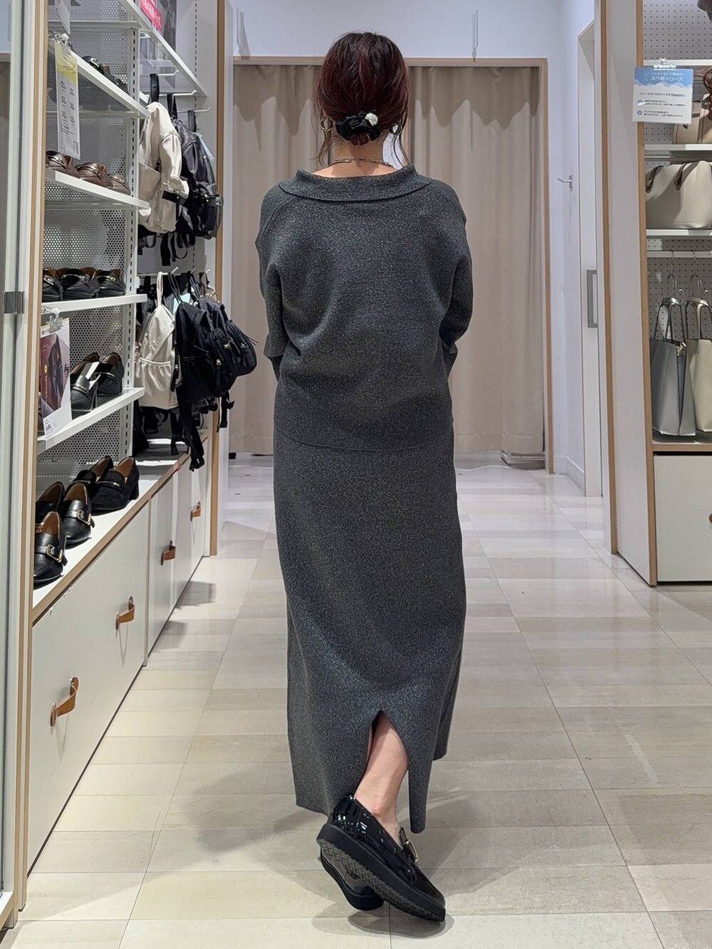 ブラック系のスニーカー、ブルー系のデニムジャケット、シルバー系のハンドバッグを着用したレディースの秋コーディネートの9枚目の写真