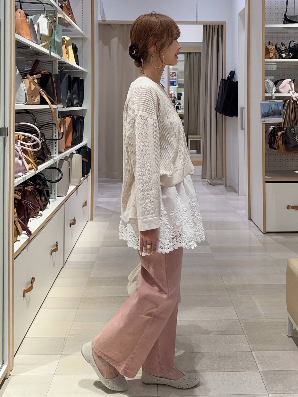 ホワイト系のショルダーバッグ、ピンク系のデニムパンツ、ホワイト系のパンプスを着用したレディースの春コーディネートの3枚目の写真