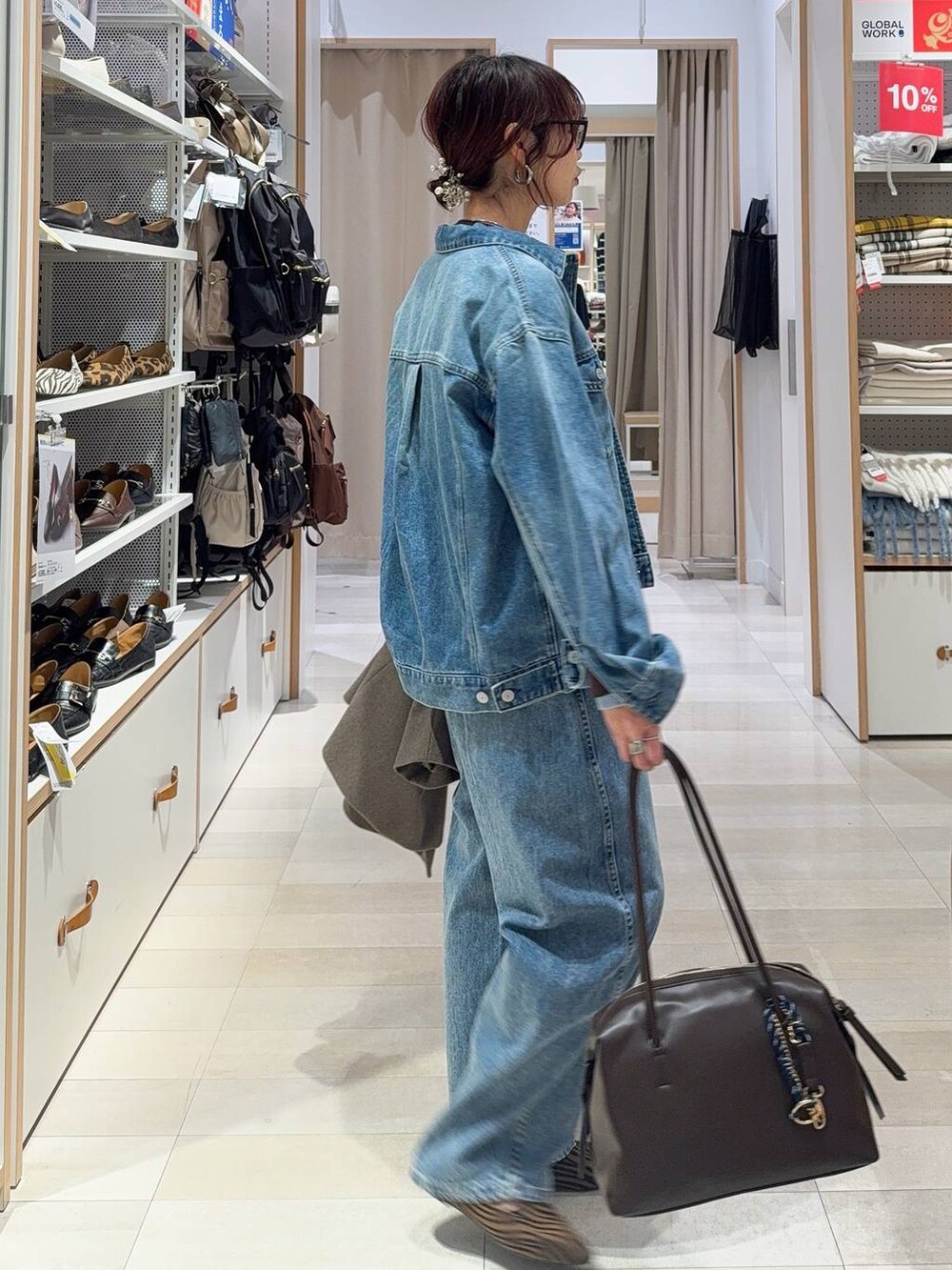 その他のパンプス、ブラウン系のボストンバッグ、ブルー系のデニムパンツを着用したレディースの冬コーディネートの6枚目の写真