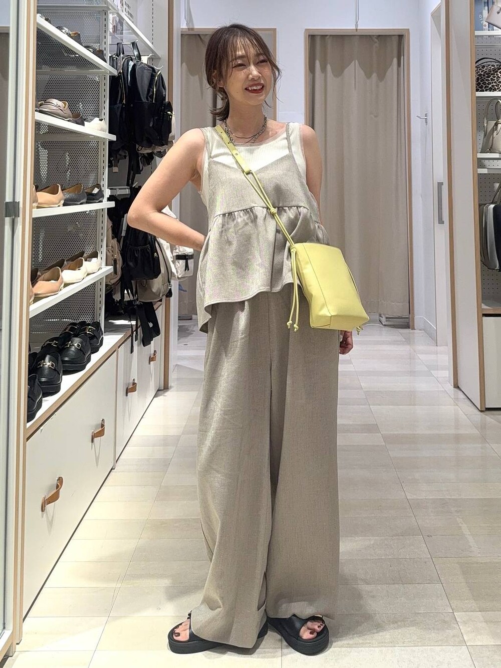 ホワイト系のタンクトップ、イエロー系のショルダーバッグ、ホワイト系のシャツ/ブラウスを着用したレディースの夏コーディネートの2枚目の写真