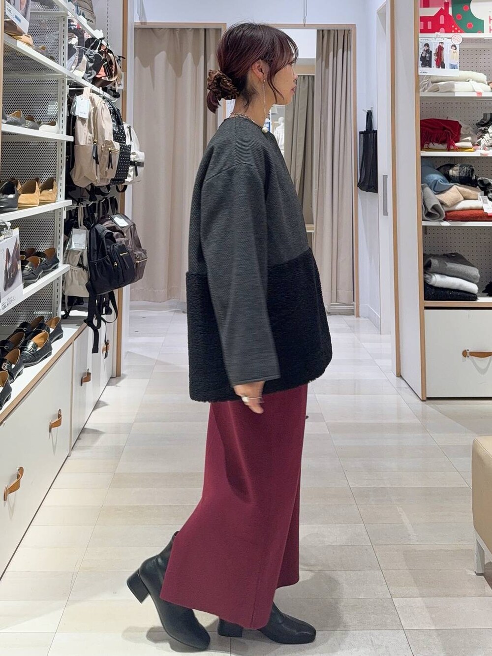 ブラック系のニット/セーター、レッド系のスカート、ブラック系のTシャツ/カットソーを着用したレディースの冬コーディネートの3枚目の写真