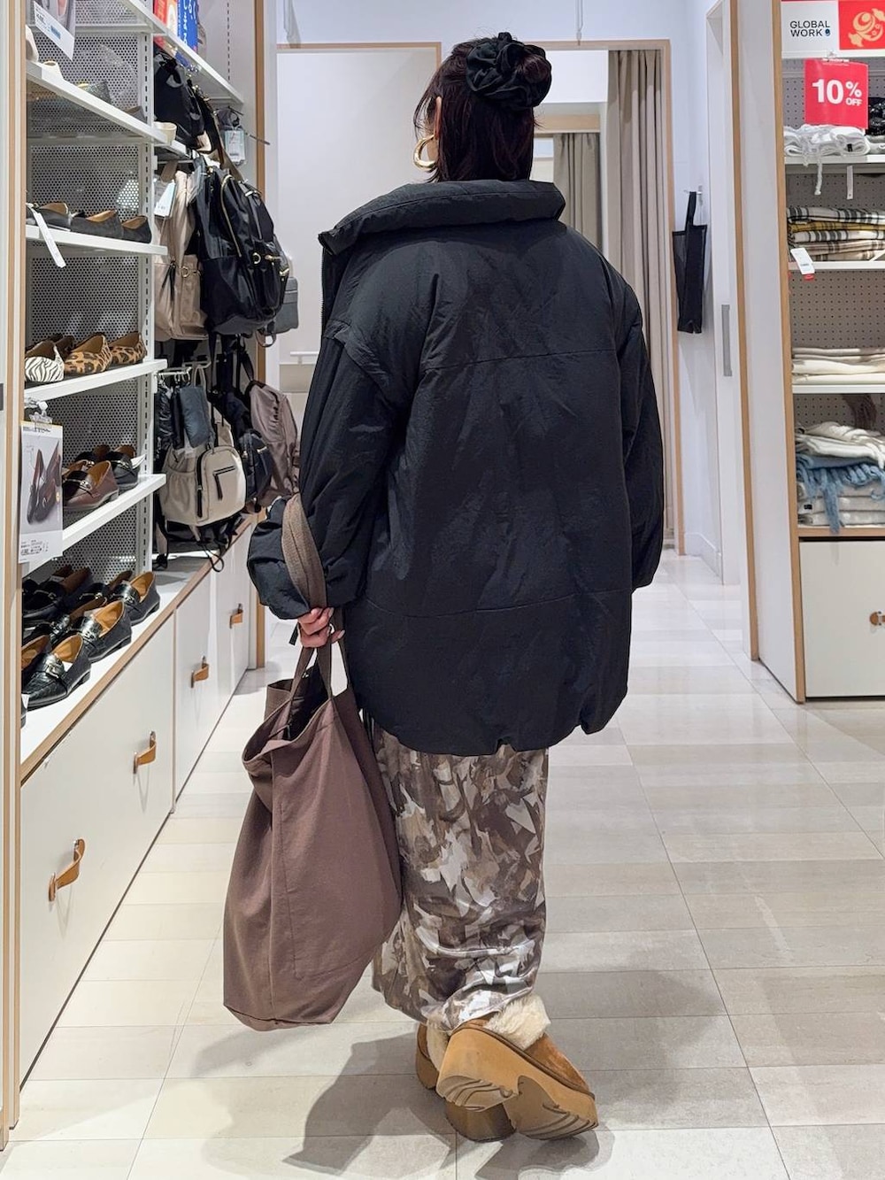 ブラック系のその他アウター、イエロー系のブーツ、ホワイト系のニット/セーターを着用したレディースの冬コーディネートの6枚目の写真