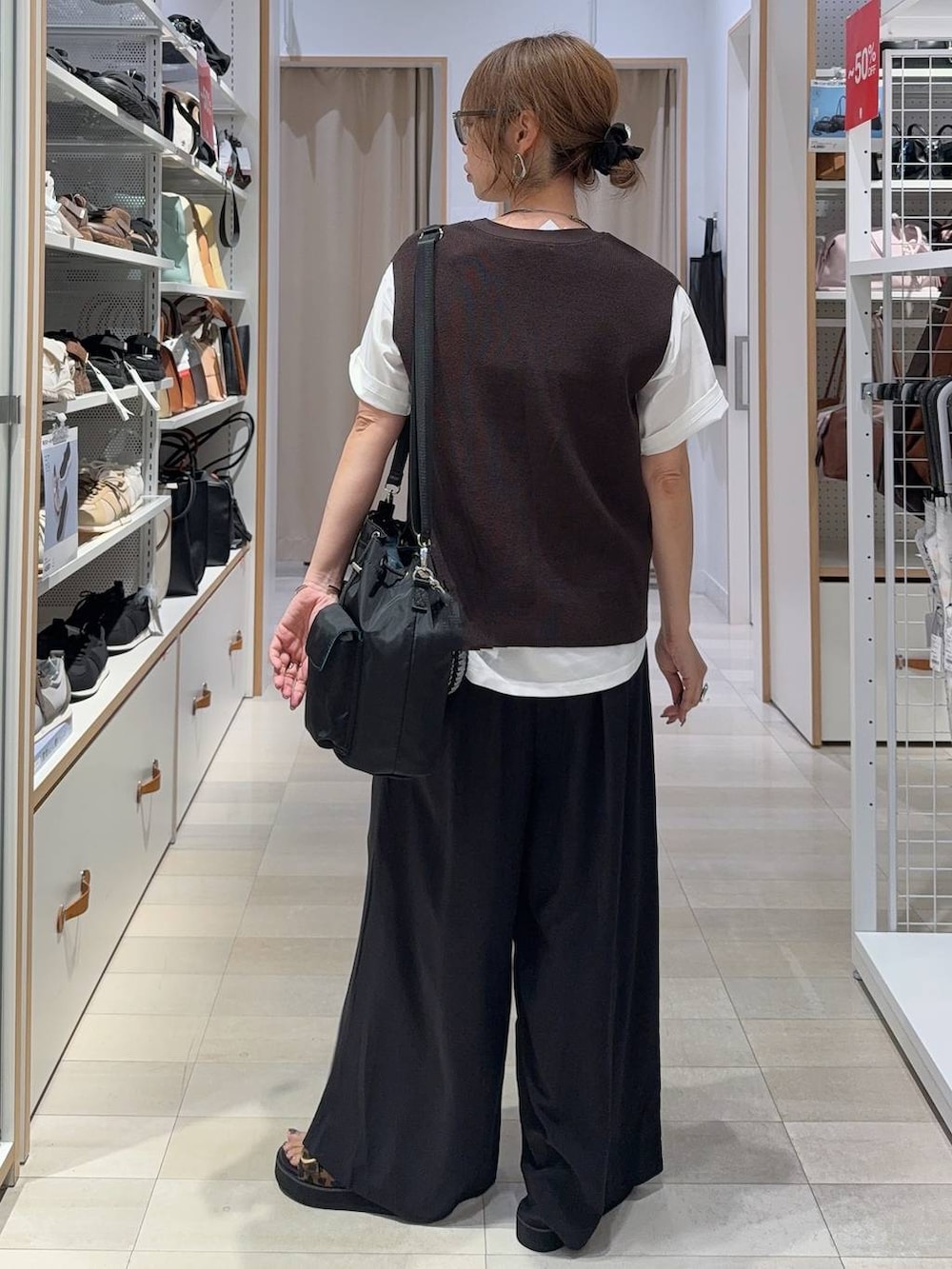 ブラック系のその他パンツ、ホワイト系のTシャツ/カットソー、ブラウン系のベストを着用したレディースの夏コーディネートの4枚目の写真