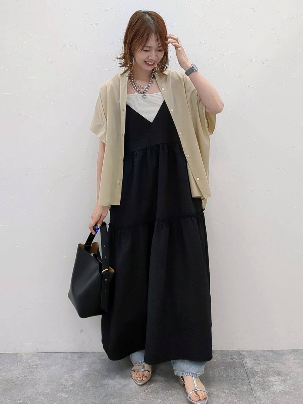 シルバー系のショルダーバッグ、グレー系のサンダル、ブラック系のワンピースを着用したレディースの夏コーディネートの2枚目の写真