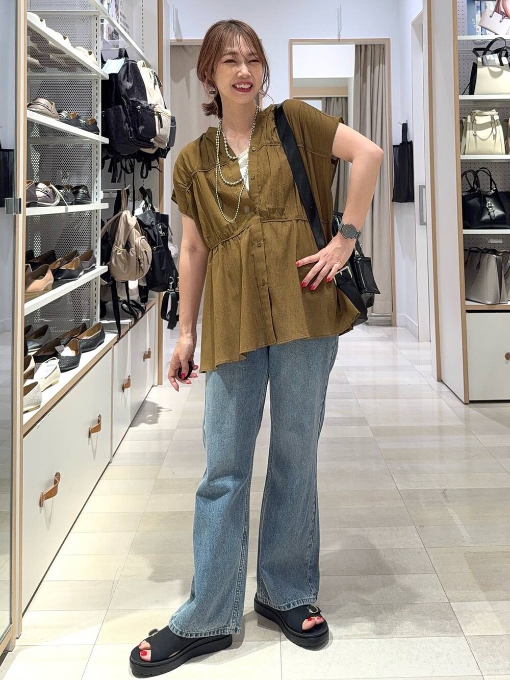 ブルー系のデニムパンツ、ベージュ系のキャミソール、ベージュ系のトートバッグを着用したレディースの夏コーディネートの5枚目の写真