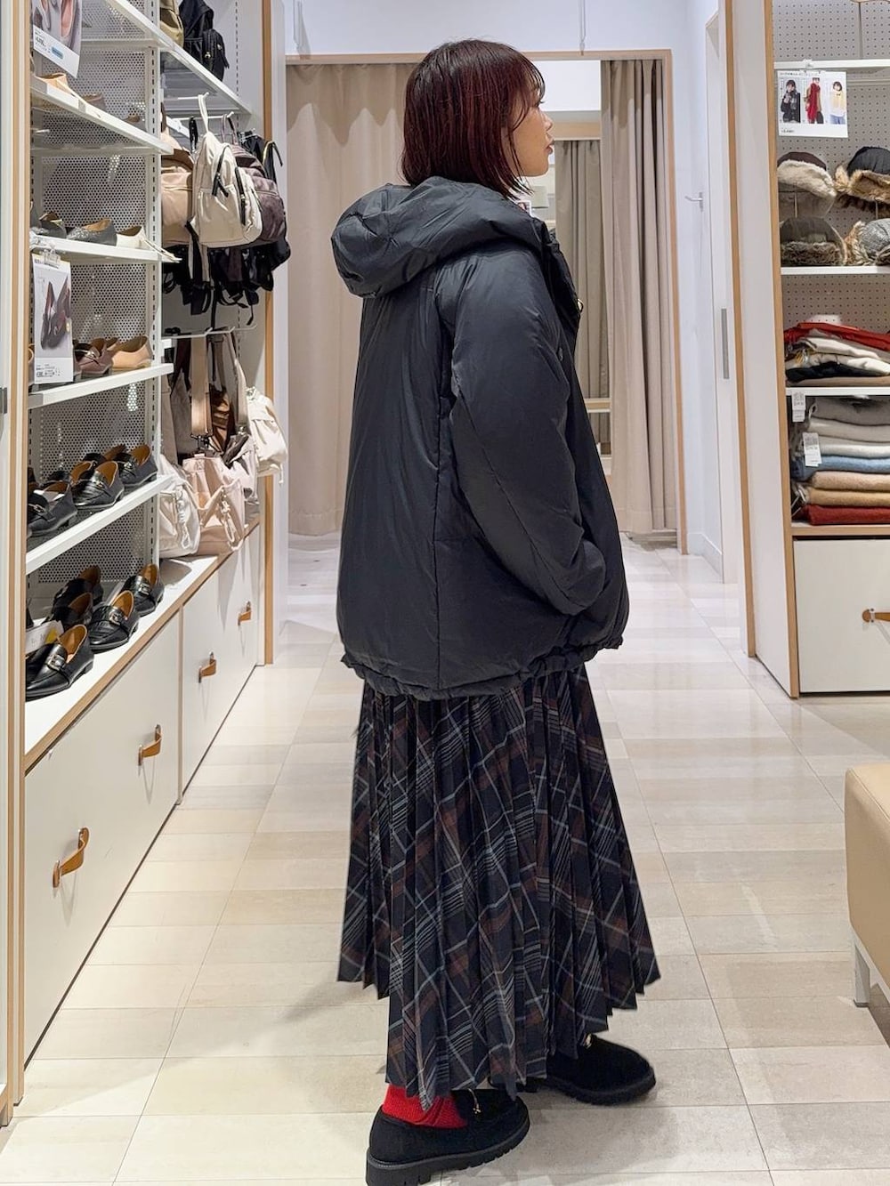 ブルー系のダウンジャケット/コート、ブラウン系のボストンバッグ、ブラック系のニット/セーターを着用したレディースの冬コーディネートの3枚目の写真