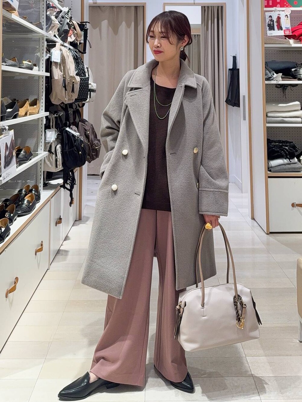 ブラック系のボストンバッグ、ベージュ系のチェスターコート、ピンク系のその他パンツを着用したレディースの冬コーディネートの2枚目の写真