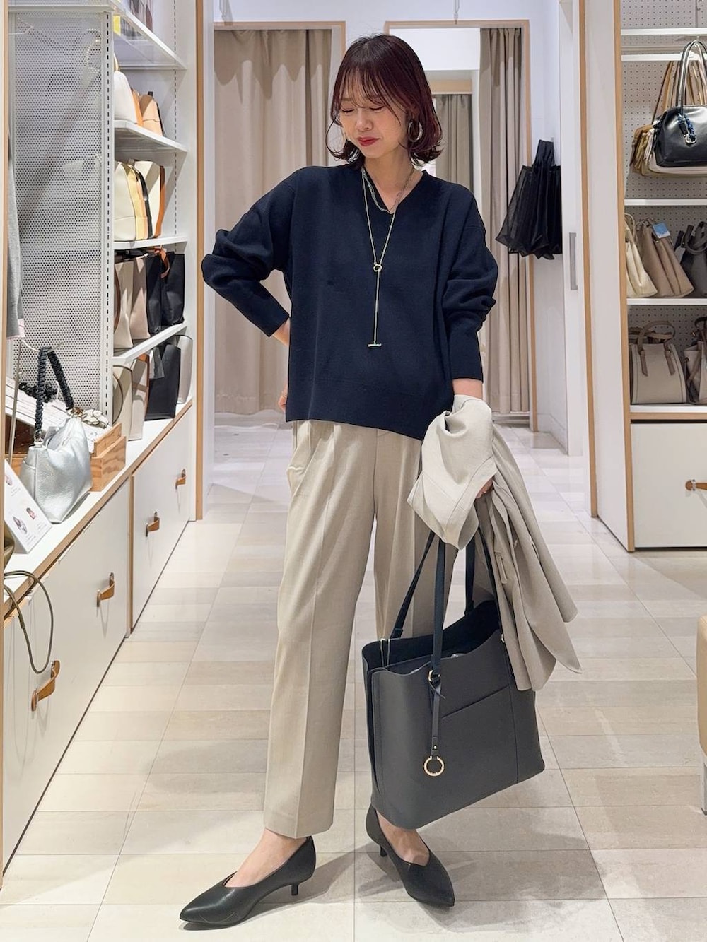 ベージュ系のスラックス、ベージュ系のノーカラージャケット、グレー系のトートバッグを着用したレディースの冬コーディネートの2枚目の写真