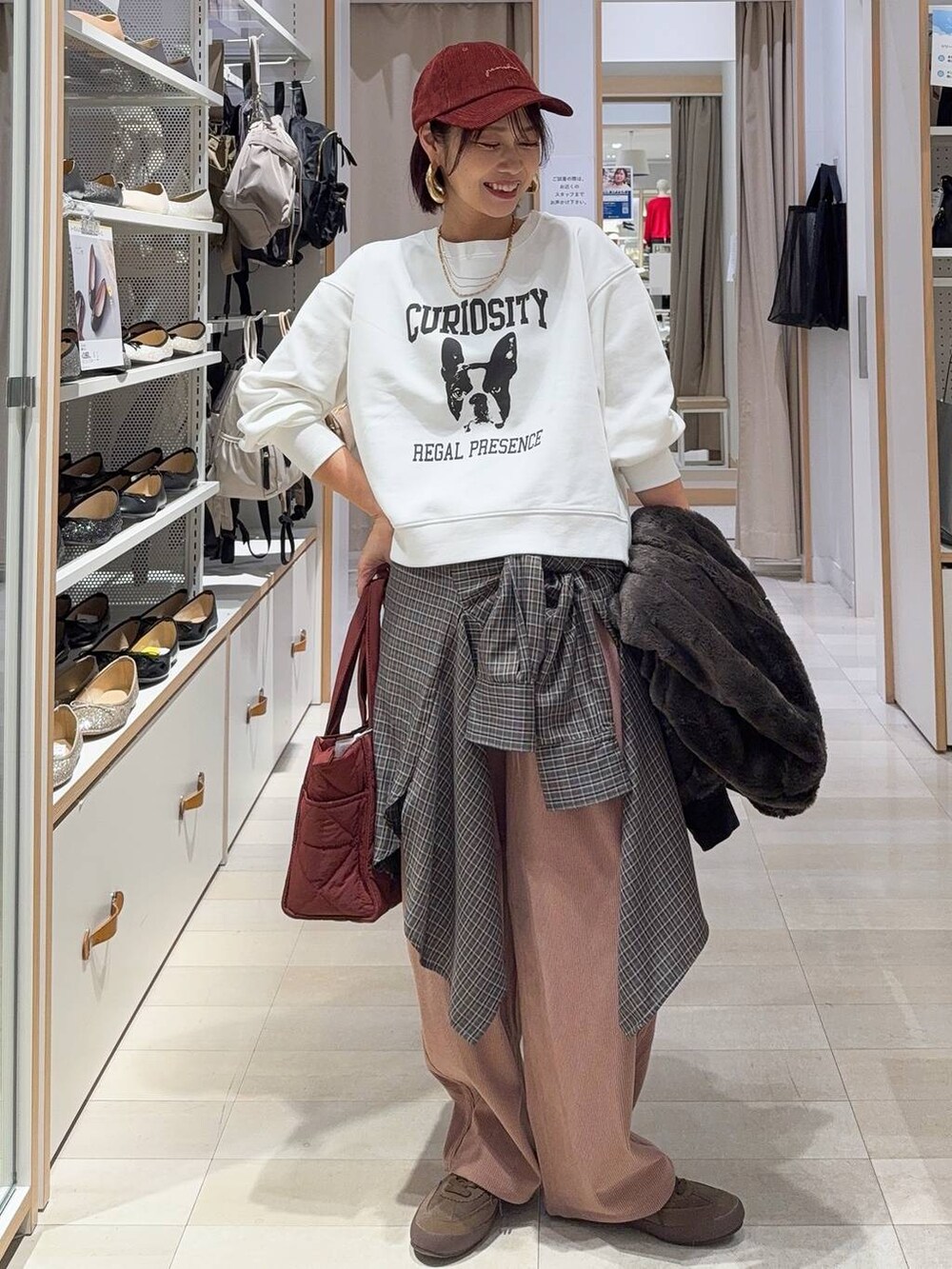 レッド系のトートバッグ、ブラック系のブルゾン、ピンク系のその他パンツを着用したレディースの秋コーディネートの2枚目の写真