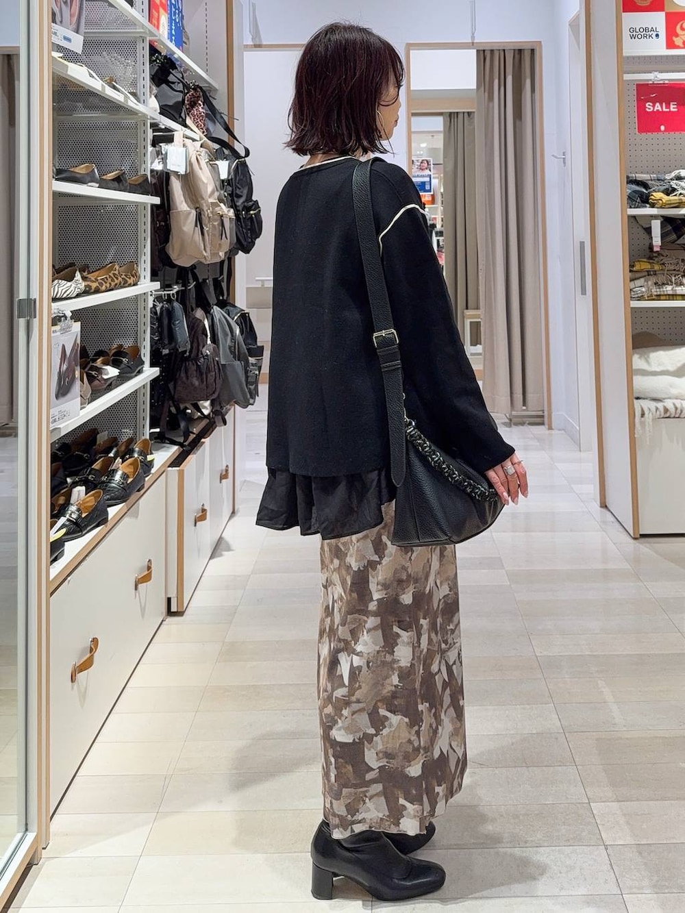 ブラック系のTシャツ/カットソー、ブラック系のワンピース、ブラック系のブーツを着用したレディースの冬コーディネートの5枚目の写真