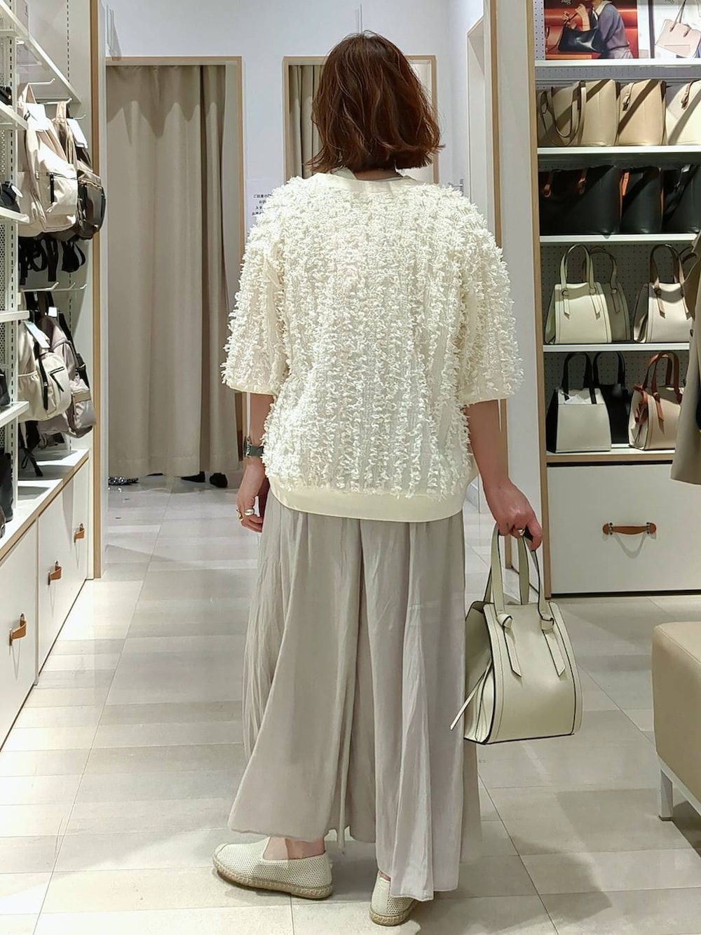 ベージュ系のその他パンツ、ホワイト系のショルダーバッグ、ホワイト系のスリッポンを着用したレディースの春コーディネートの5枚目の写真