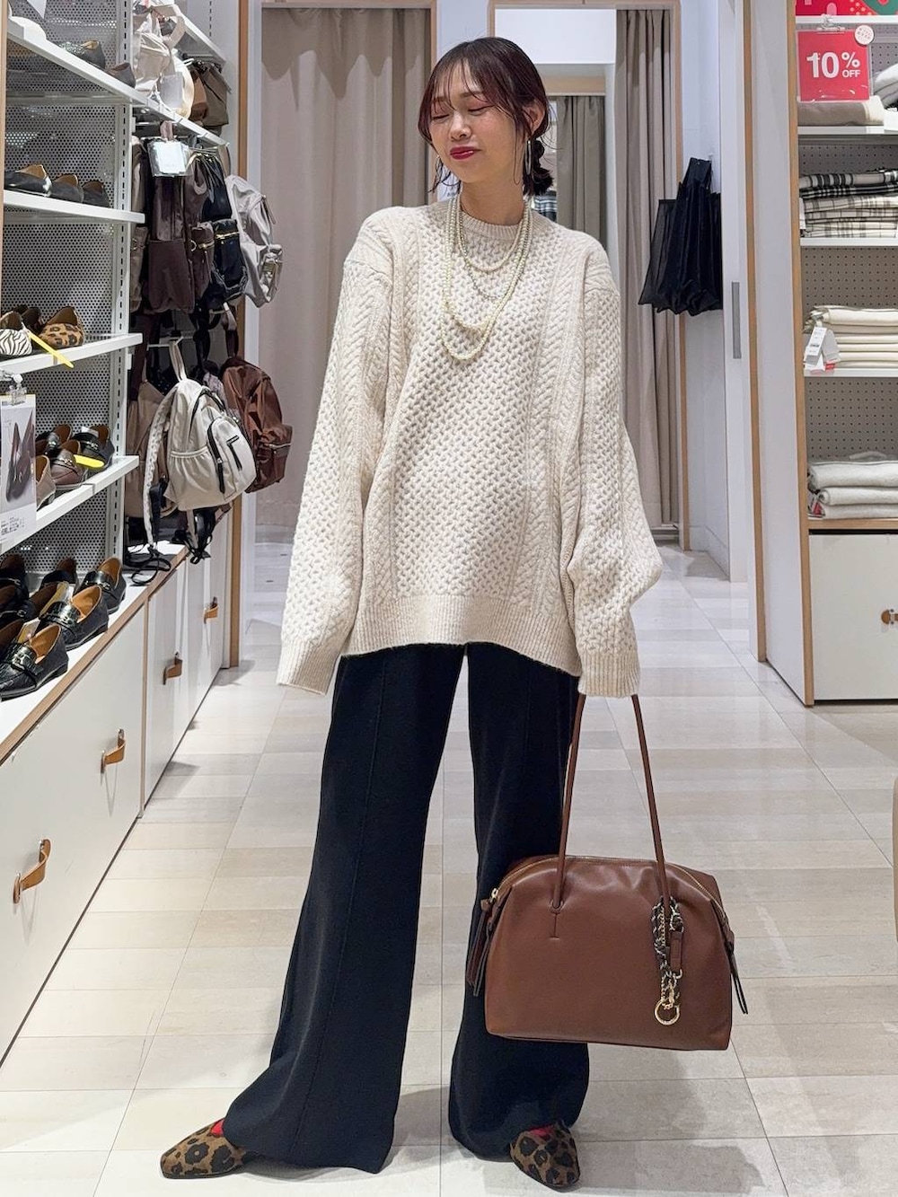 ブラウン系のボストンバッグ、ブルー系のデニムパンツ、ブラウン系のチェスターコートを着用したレディースの冬コーディネートの4枚目の写真