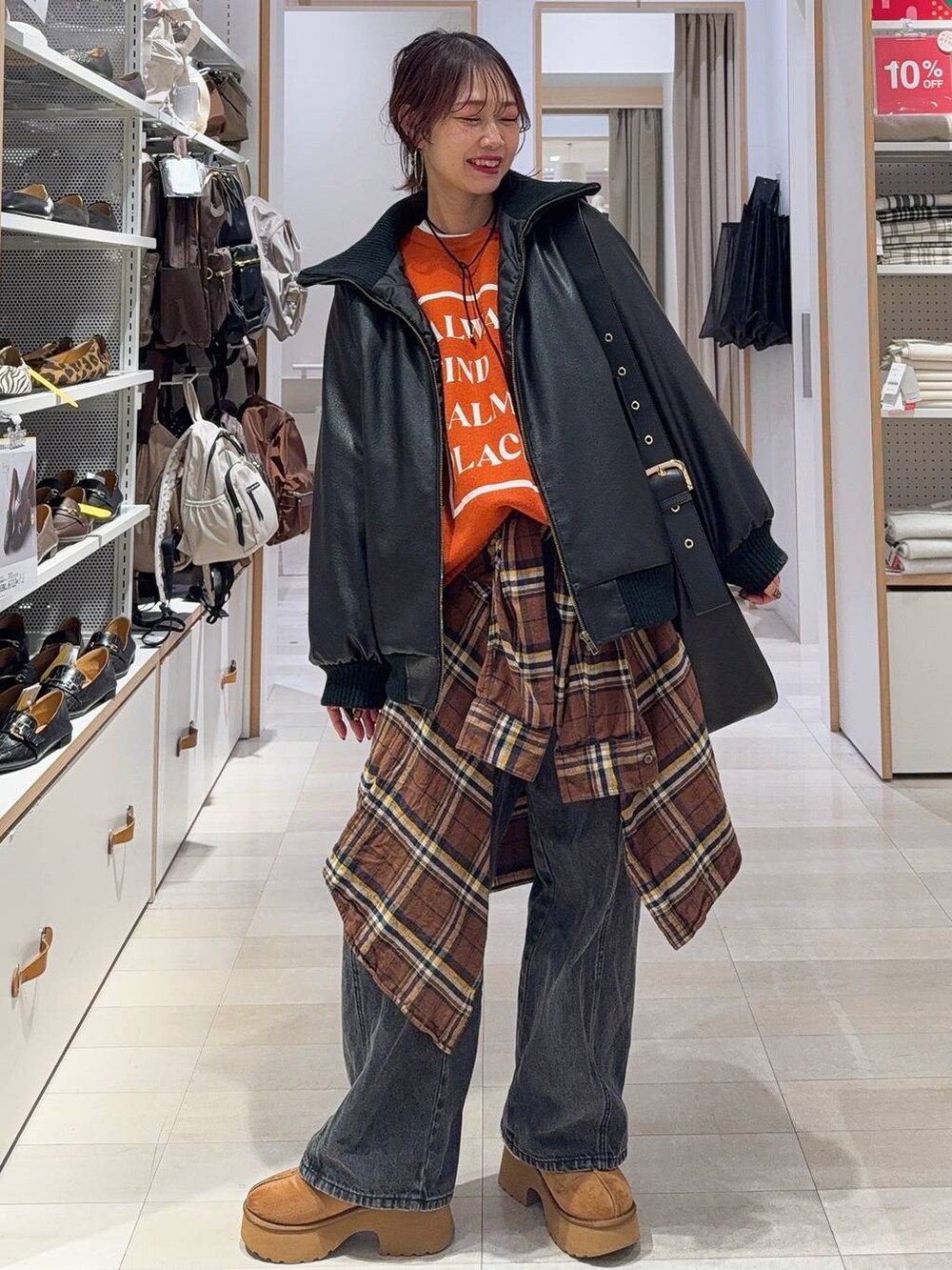 ブラック系のショルダーバッグ、ブラウン系のシャツ/ブラウス、イエロー系のブーツを着用したレディースの冬コーディネートの2枚目の写真