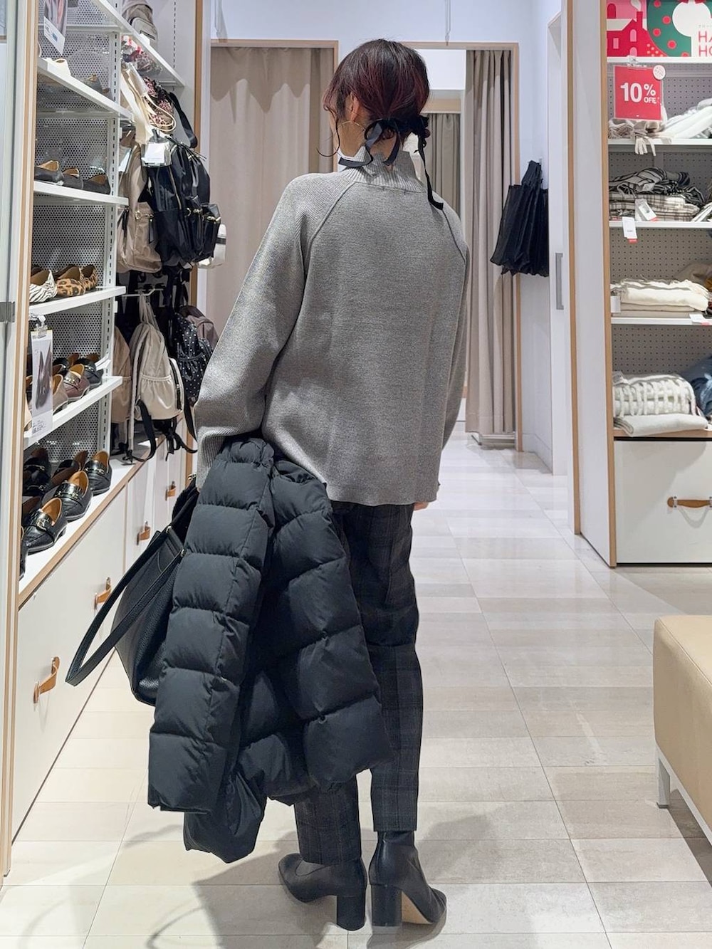 ブラック系のダウンジャケット/コート、ブラック系のその他パンツ、グレー系のニット/セーターを着用したレディースの冬コーディネートの7枚目の写真