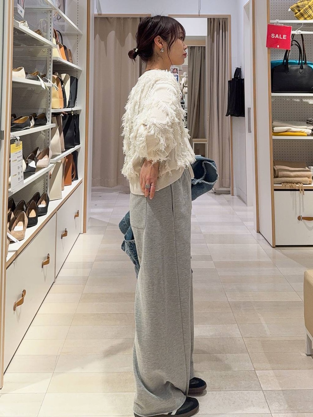 ブラック系のキャミソール、ホワイト系のハンドバッグ、ブルー系のデニムジャケットを着用したレディースの冬コーディネートの5枚目の写真