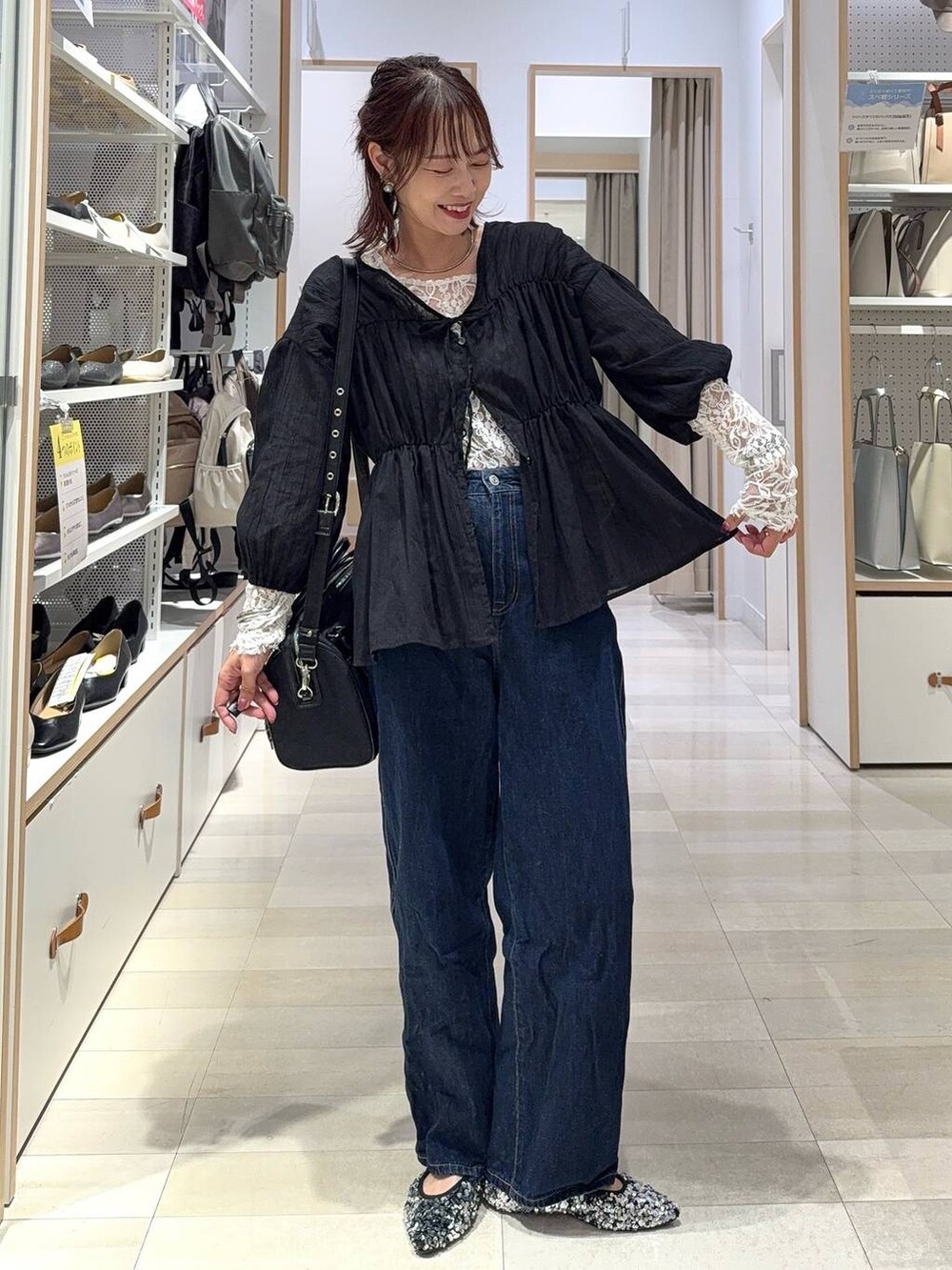 ブルー系のデニムパンツ、ブラック系のボストンバッグ、ブラック系のシャツ/ブラウスを着用したレディースの秋コーディネートの3枚目の写真