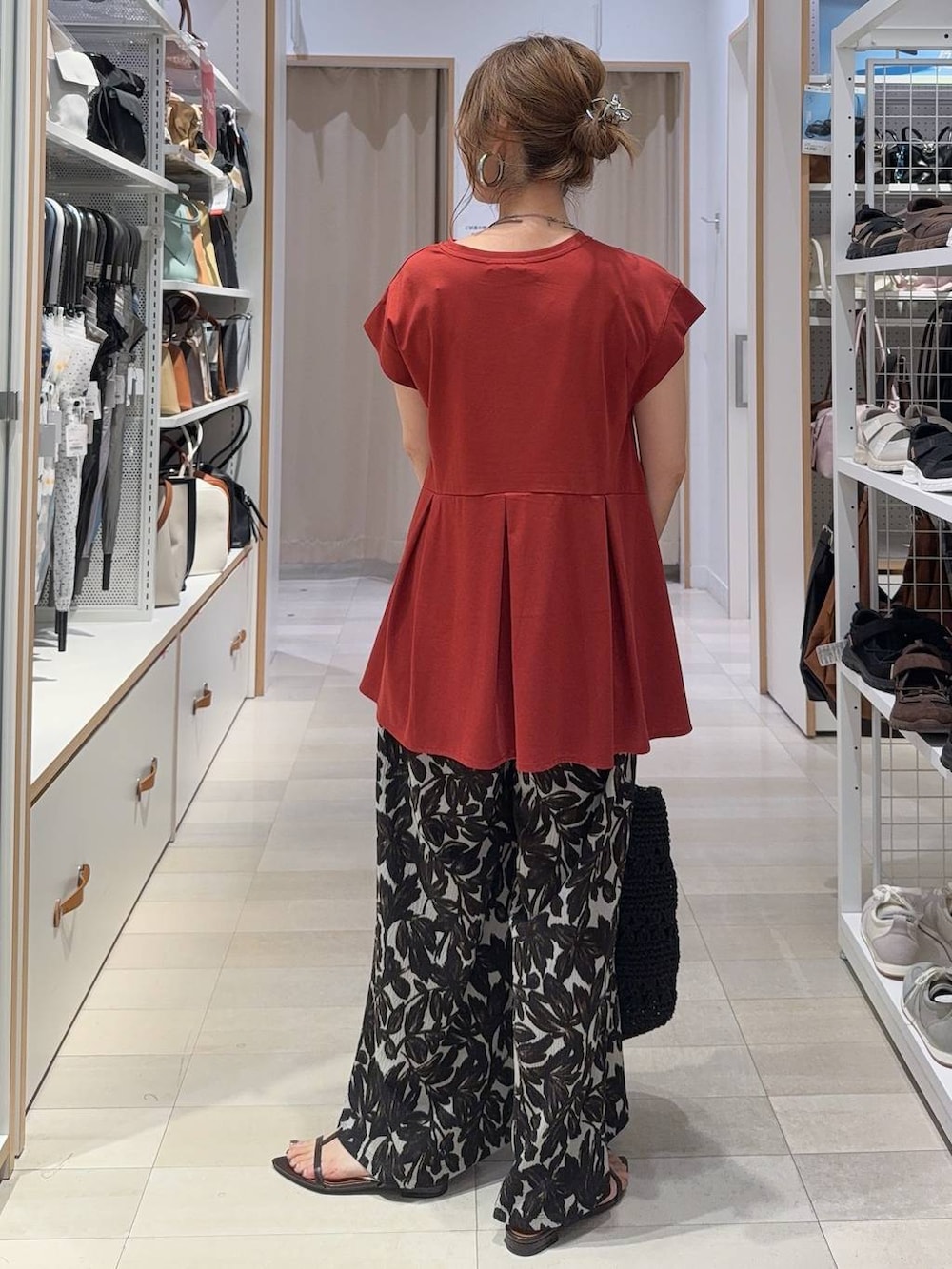 ベージュ系のその他パンツ、レッド系のTシャツ/カットソー、ブラック系のトートバッグを着用したレディースの夏コーディネートの6枚目の写真