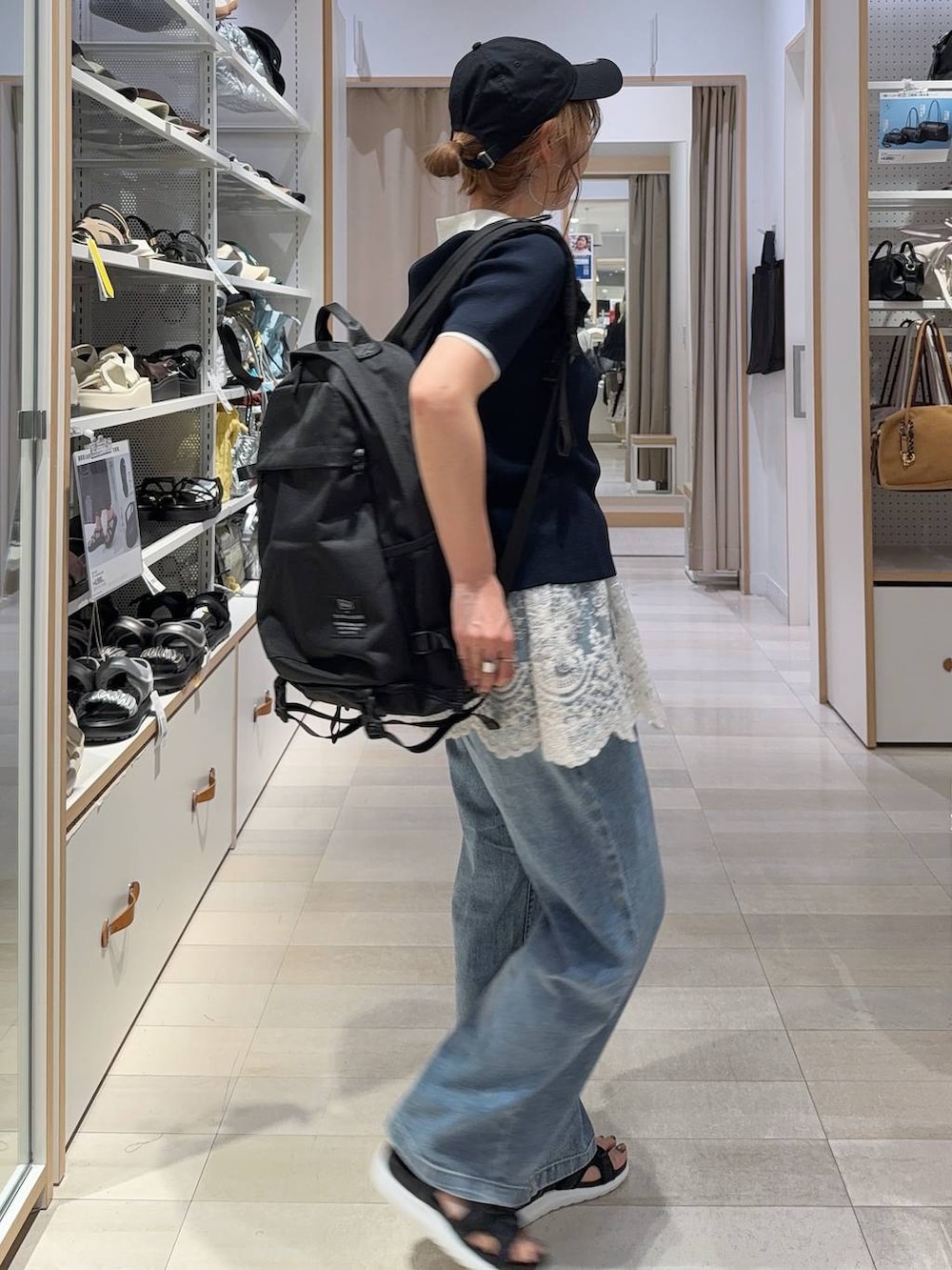 ブルー系のデニムパンツ、ブラック系のサンダル、ブルー系のニット/セーターを着用したレディースの夏コーディネートの3枚目の写真