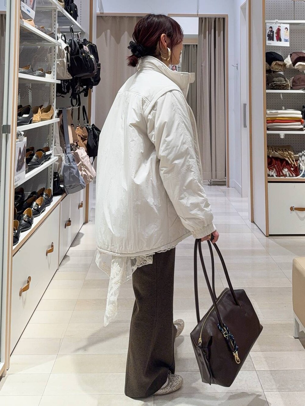 ゴールド系のバレエシューズ、ベージュ系のブルゾン、ブラウン系のボストンバッグを着用したレディースの冬コーディネートの3枚目の写真