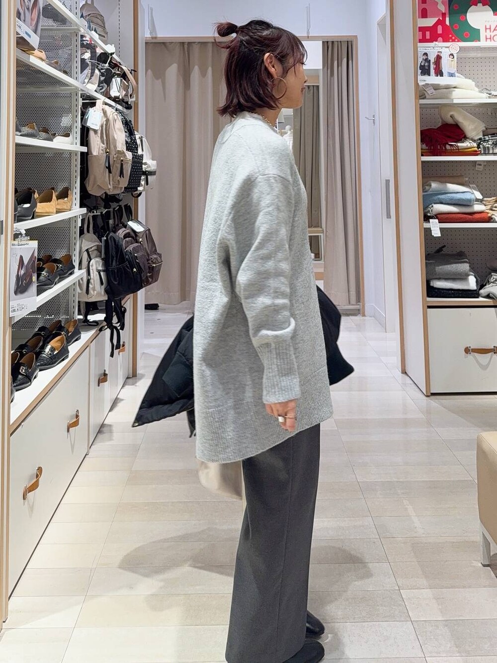 ホワイト系のショルダーバッグ、ブラック系のダウンジャケット/コート、ホワイト系のニット/セーターを着用したレディースの冬コーディネートの6枚目の写真