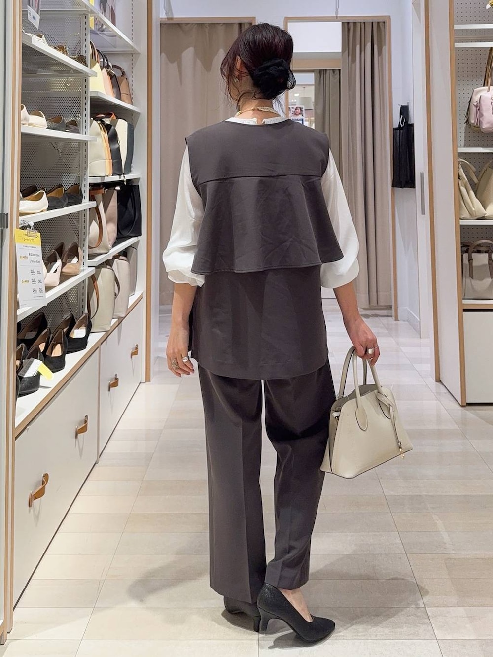 ホワイト系のショルダーバッグ、ブラック系のパンプス、グレー系のセットアップを着用したレディースの冬コーディネートの4枚目の写真