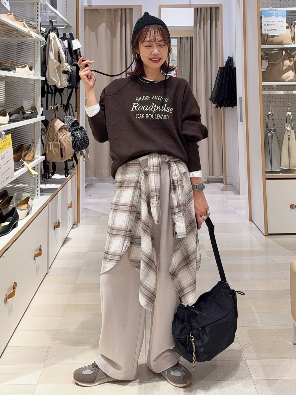 ブラウン系のボストンバッグ、グレー系のチェスターコート、レッド系のスカートを着用したレディースの秋コーディネートの3枚目の写真